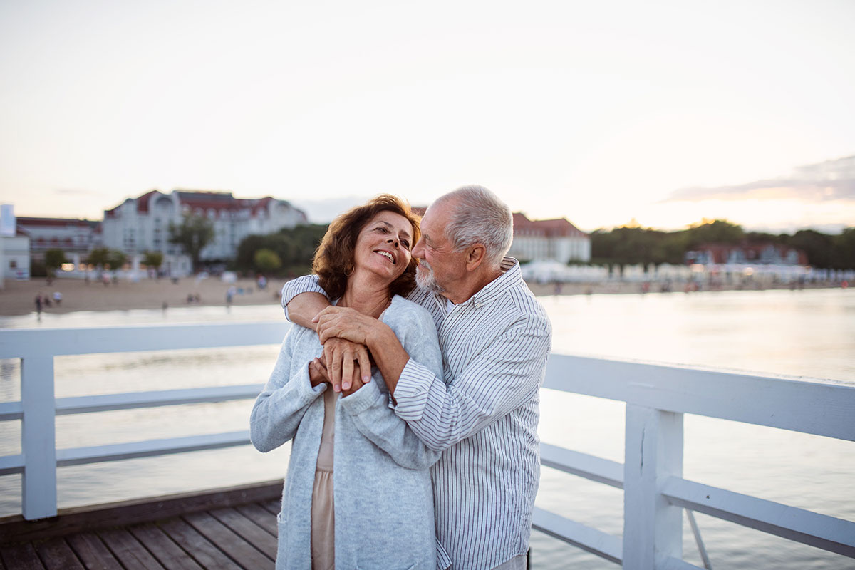 happy senior couple hugging outdoors enjoying retirement